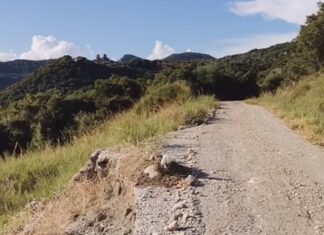 Πανό για τα χάλια του δρόμου προς το Ησυχαστήριο Μεταμορφώσεως του Σωτήρος, στην Παραβόλα